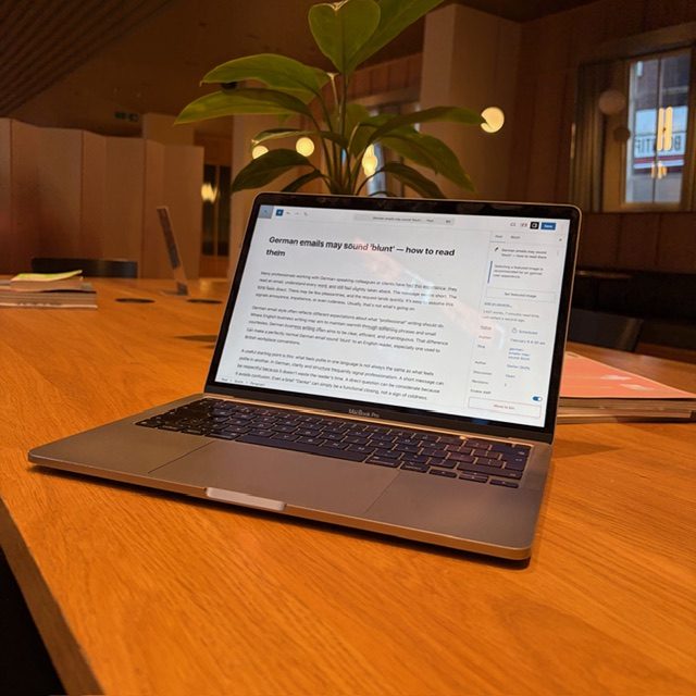 Professional reading a business email on a laptop screen in an office setting